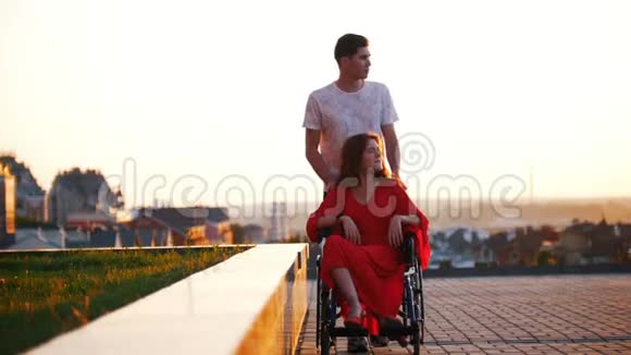一个残疾的女孩在轮椅外门上翻滚视频的预览图