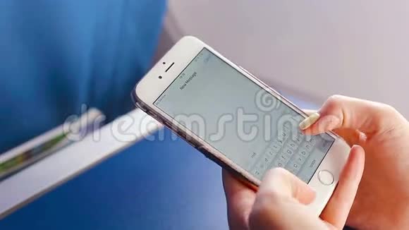 女人在手机上发短信飞机背景窗口内的特写显示视频的预览图