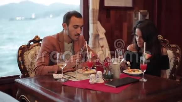 一对夫妇在餐馆里坐船旅行背景是大海视频的预览图