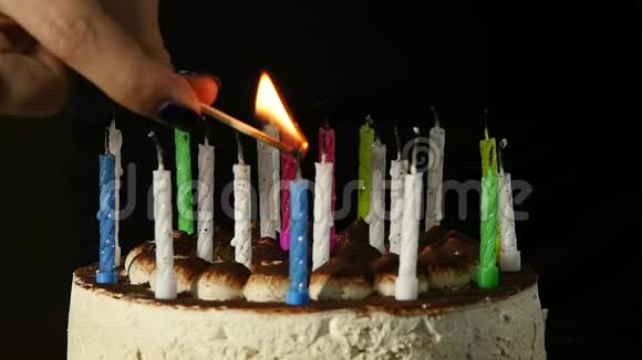 特写的女人在美味的生日蛋糕上点燃蜡烛慢动作视频的预览图
