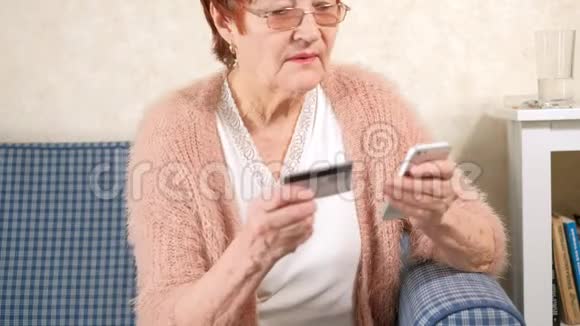 一位老妇人用信用卡和电话进行银行转账视频的预览图