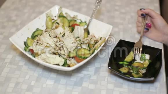 女人的手把新鲜蔬菜沙拉放在碗里然后在外面吃视频的预览图
