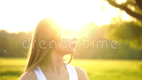年轻漂亮的女人跑步时在公园听音乐带耳机的微笑运动女孩的肖像视频的预览图