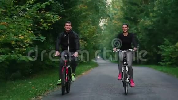 一个英俊的留胡子的职业男性自行车手和他的女朋友一起骑着他的赛车视频的预览图