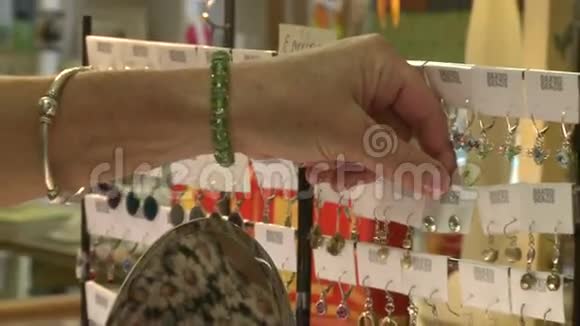 在珠宝拍卖会上看耳环的女人视频的预览图