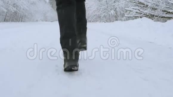 女孩在冬天的森林里在路上奔跑从下面的双脚特写视频的预览图