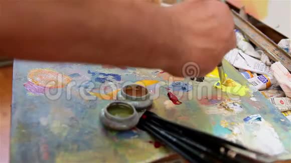 艺术家在调色板上混合油漆艺术在调色板上刷混合油漆艺术家在调色板上刷混合彩色油画视频的预览图