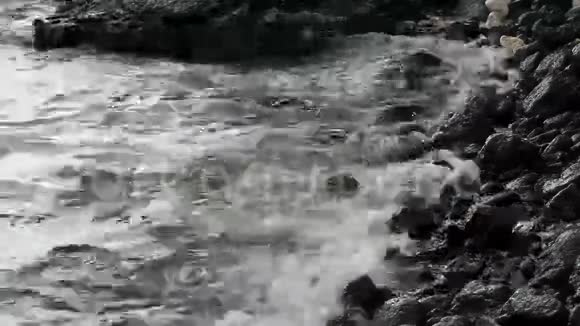 黑色熔岩海滩上的小海浪视频的预览图