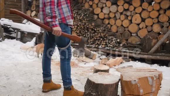 伐木工人在雪地里用斧头砍木头视频的预览图