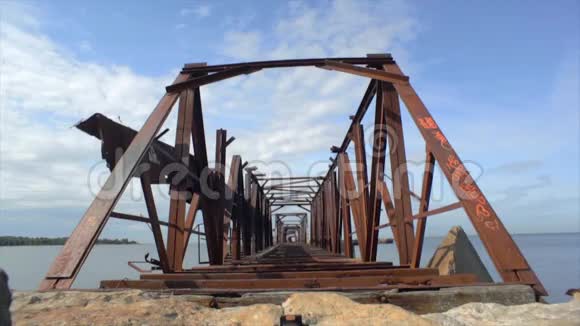 旧的巨大废弃的铁路生锈的桥在水面上海岸夏天放大视频的预览图