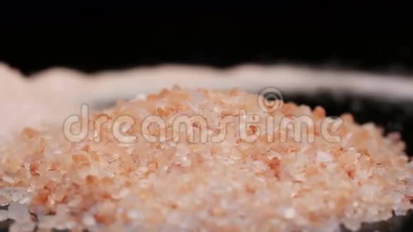 一堆粉红色喜马拉雅山岩盐在黑色上分离旋转视频的预览图
