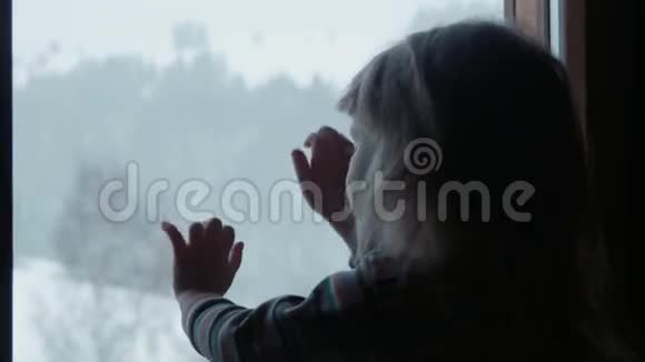冬天窗后的小可爱女孩视频的预览图