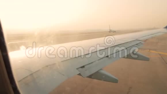 日出时本古里昂机场跑道上的飞机机翼视频的预览图
