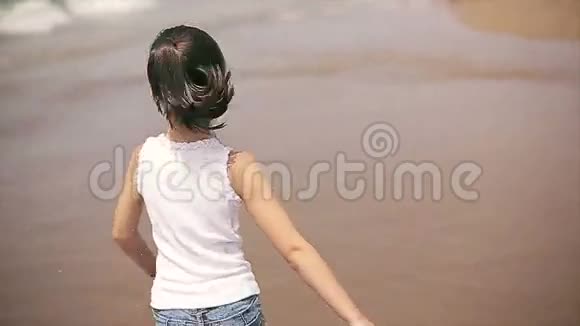 快乐的孩子沿着海滩奔跑慢动作视频的预览图