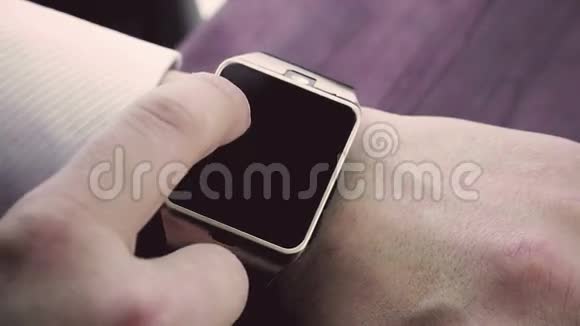 使用智能手表应用程序的人用手指在木桌上视频的预览图