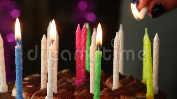 特写的女人在美味的生日蛋糕上点燃蜡烛慢动作视频的预览图