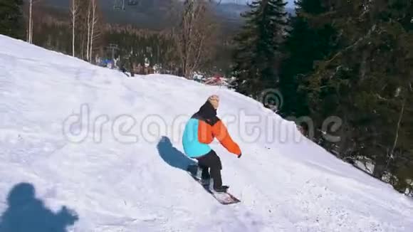快乐的滑雪者在雪山的一个阳光明媚的冬日玩着快乐的滑雪板穿鲜艳颜色的男人视频的预览图