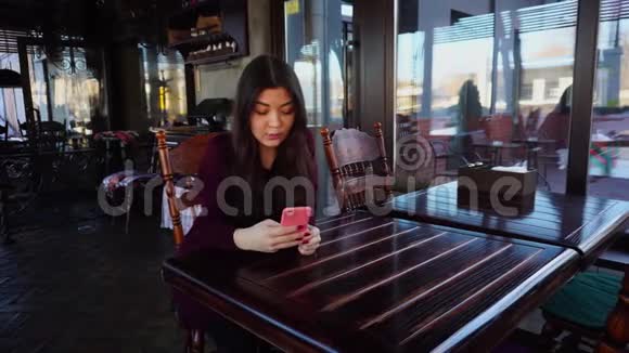 漂亮的女孩在粉红色的情况下和智能手机聊天视频的预览图