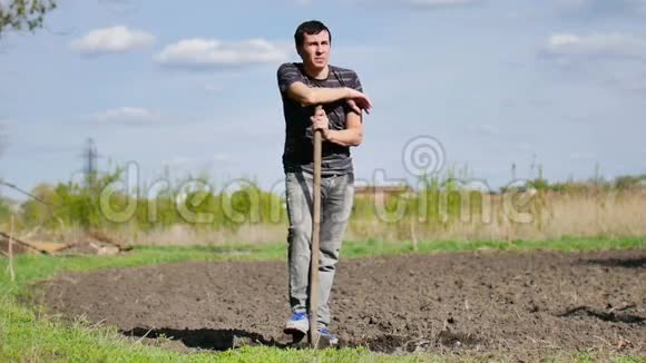 农夫疲倦的人在干地上挖地旧脏铲子慢动作视频的预览图