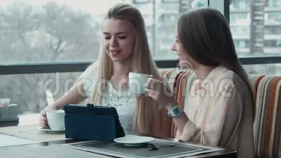 女孩在触摸板上向女朋友展示一些东西视频的预览图