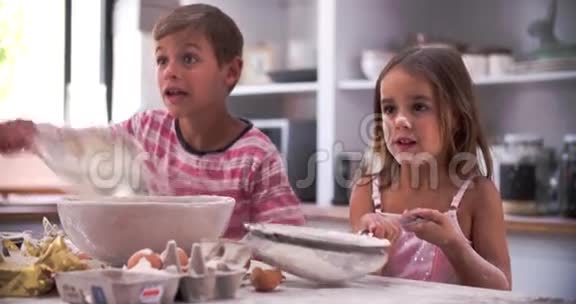 儿童在厨房中享受混乱乐趣的慢动作镜头视频的预览图