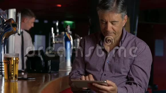 在酒吧喝一品脱的人用平板电脑视频的预览图