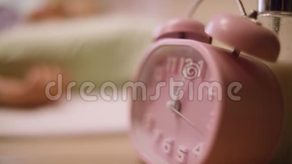 粉色闹钟站在床头柜上的粉红钟视频的预览图