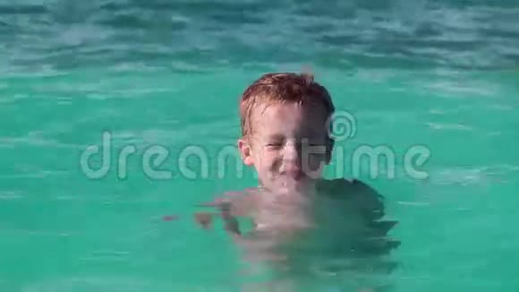 小男孩在碧蓝的大海里洗澡视频的预览图