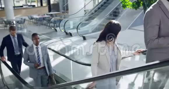 商务人士在现代化办公室使用自动扶梯视频的预览图