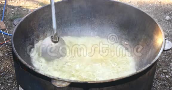 黄油煎锅中的洋葱圈与大勺混合视频的预览图