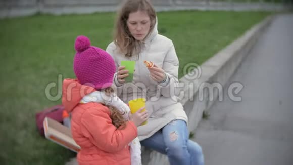 一个漂亮的小女孩和她妈妈在户外吃披萨营养食物和生活方式视频的预览图