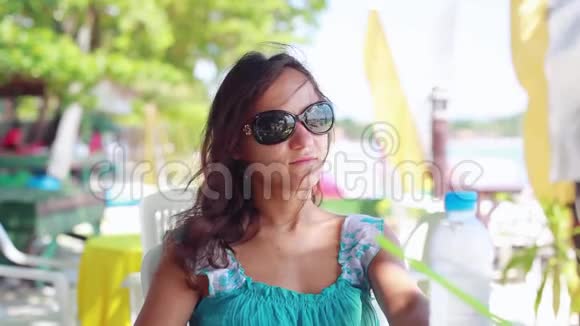 穿着太阳镜在海滩咖啡馆喝水的漂亮女孩1920x1080视频的预览图