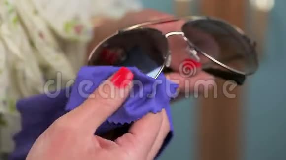 女人用餐巾清洁太阳镜视频的预览图