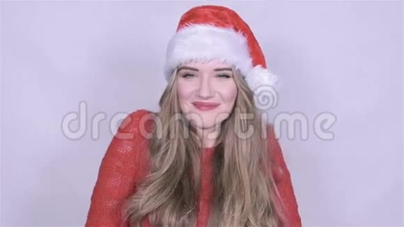 快乐迷人的年轻女子在圣诞帽降雪背景视频的预览图