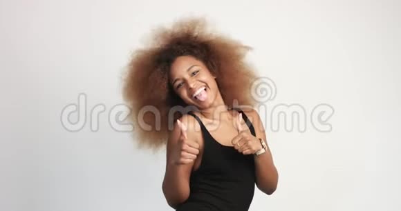 美丽的黑人女人有着巨大的非洲头发开心地微笑着抚摸她的头发视频的预览图
