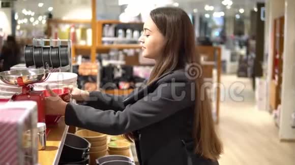 美丽的女人在商店超市挑选餐具视频的预览图