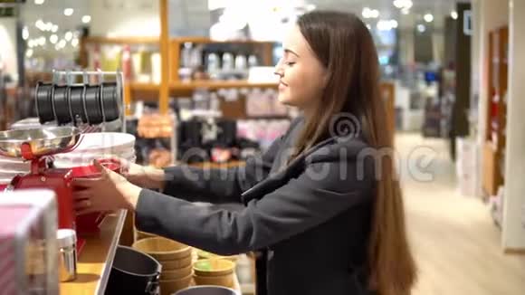 美丽的女人在商店超市挑选餐具视频的预览图