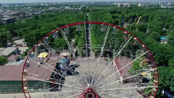 公园内摩天轮鸟瞰一个巨大的摩天轮在一个绿色公园的中央与无人机拍摄视频的预览图