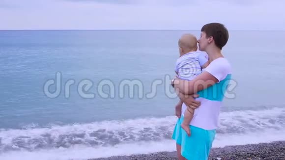 妈妈带着一个孩子走在海滩上视频的预览图