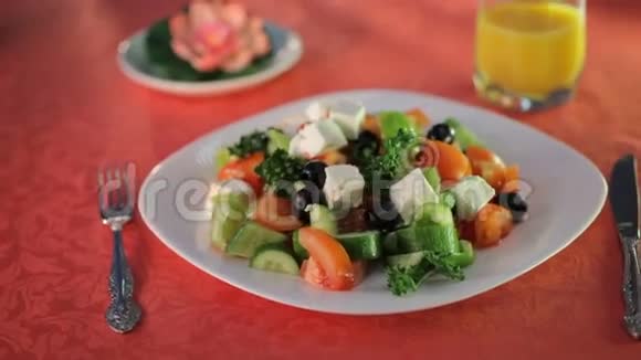 橄榄油倒在白色盘子上的混合沙拉上视频的预览图