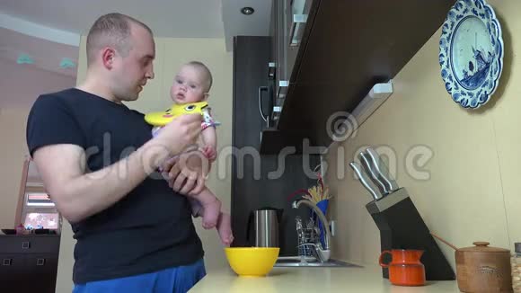 爸爸和小女儿说话用勺子喂土豆泥4K视频的预览图