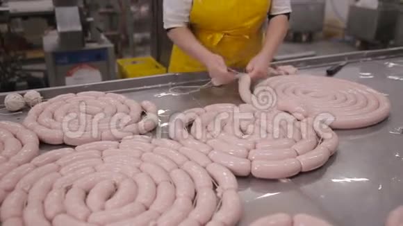 在自动化肉类加工设备上制作香肠肉类美味的工人视频的预览图