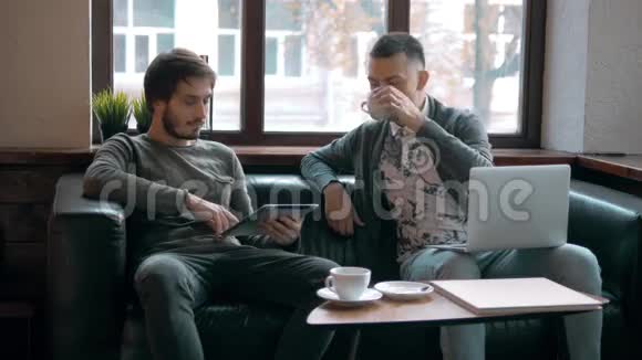 两个企业家在小办公室的桌子上一起工作和做笔记自由职业者会议带手提电脑的男人视频的预览图