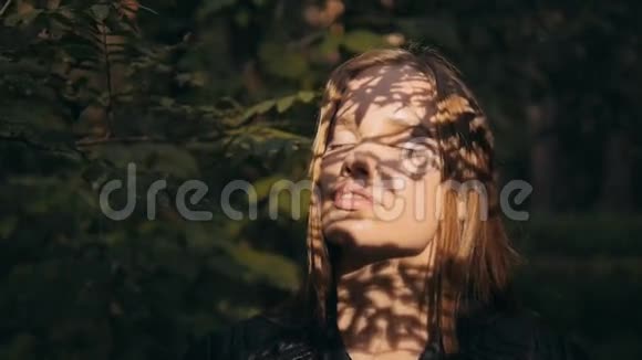 特写一幅美丽的年轻黑发女子的画像她的头发在森林里随风飘扬视频的预览图