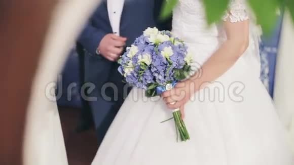 婚礼上新娘带着一束粉红色的花新郎穿着蓝色的西装视频的预览图