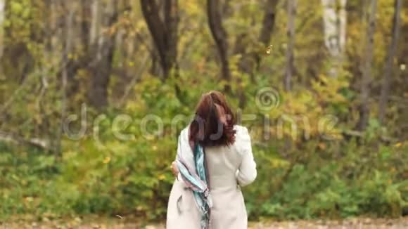 快乐的年轻女子正在跳舞走在秋天的公园里视频的预览图
