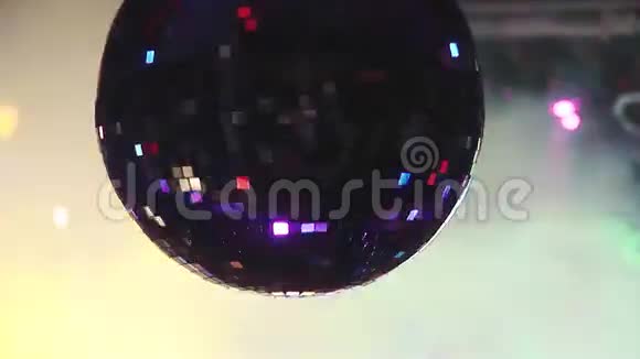 旋转的迪斯科球反射出闪闪发光的彩色光束从聚光灯在夜总会抽烟假期视频的预览图