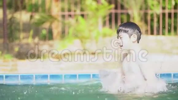 年轻的亚洲男孩在游泳池里玩慢动作视频的预览图