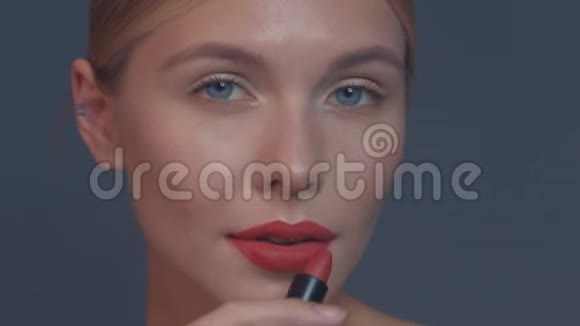 漂亮的女孩红唇和经典的化妆口红在工作室的手姿势美丽的脸视频的预览图