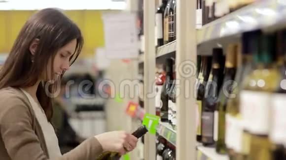 女人挑选商店货架上的酒视频的预览图